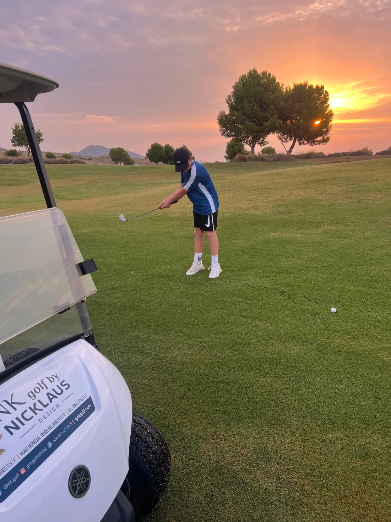 Chipping onto the green as the sun sets behind the pines